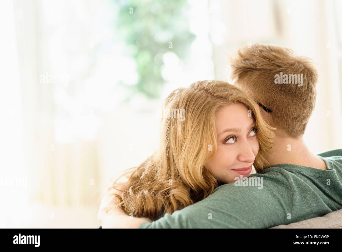 Jeune femme regardant par-dessus l'épaule de petit ami Banque D'Images