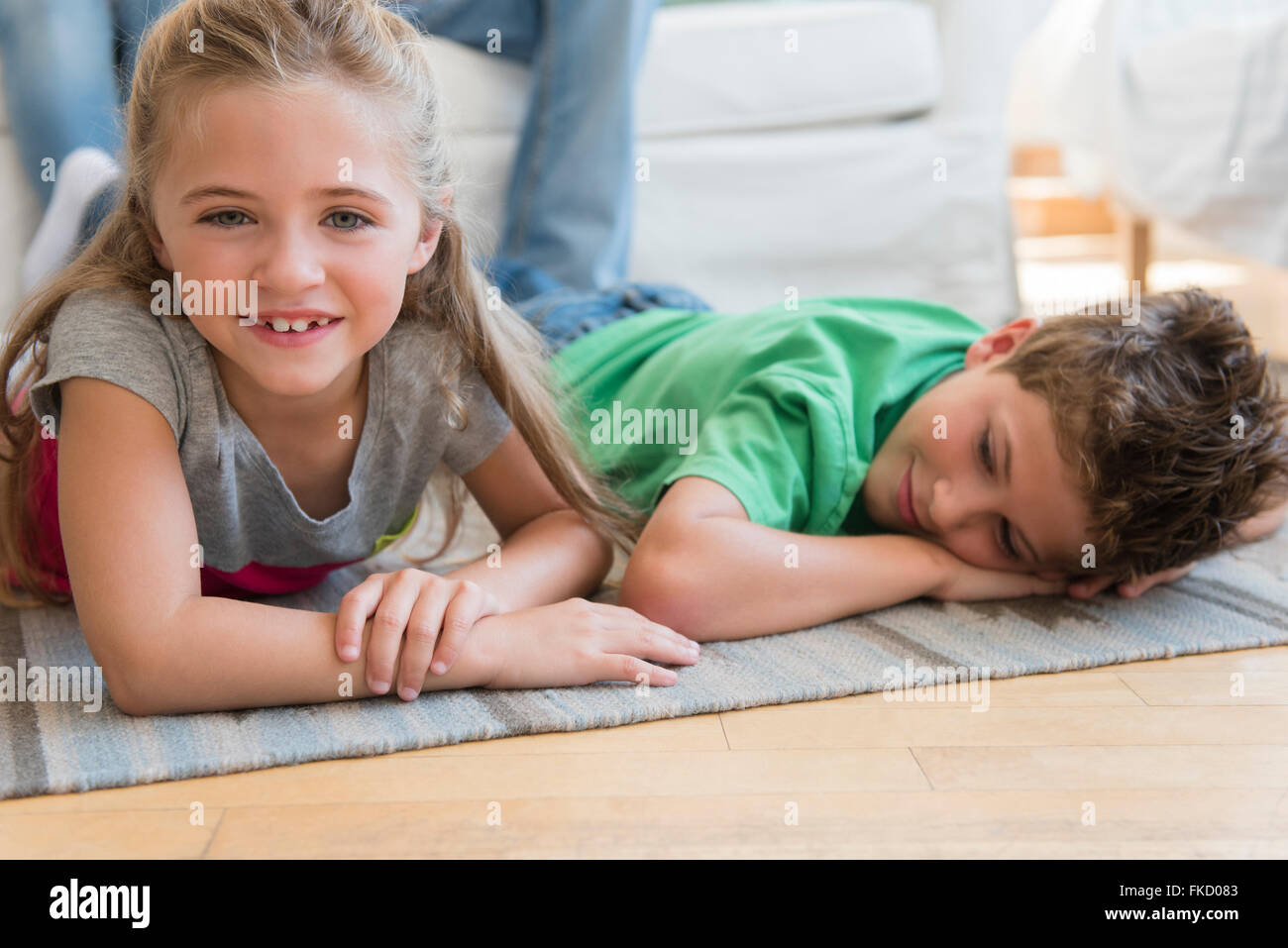 Boy and girl (6-7, 8-9) lying on floor Banque D'Images