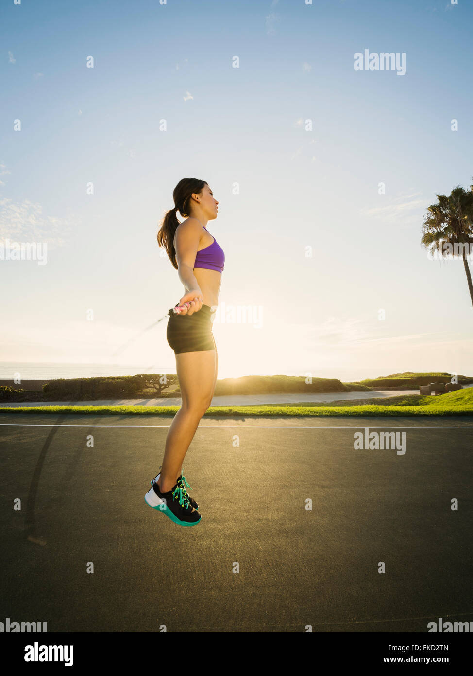 Young woman jumping rope in park Banque D'Images