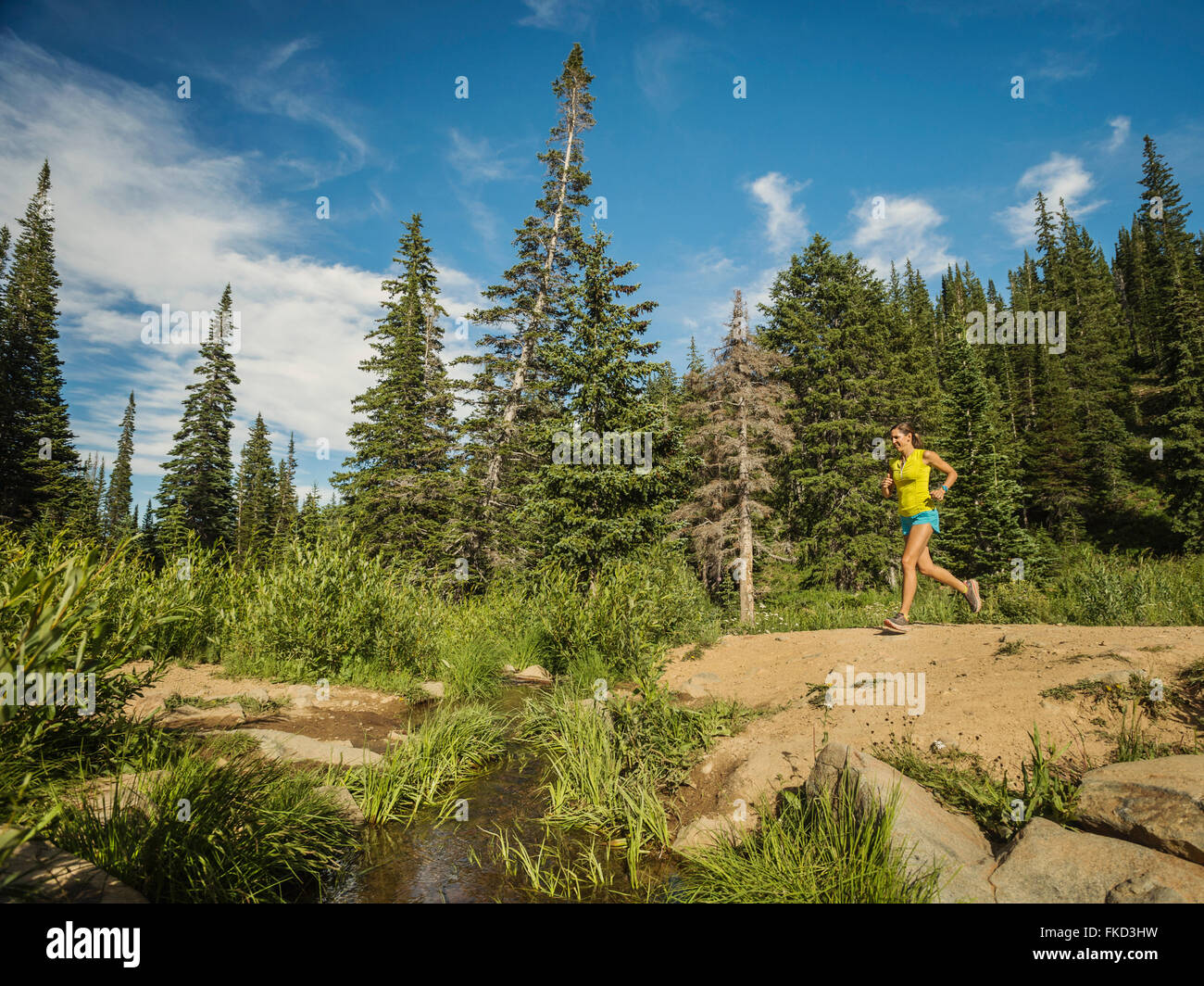 Young woman running in forest Banque D'Images