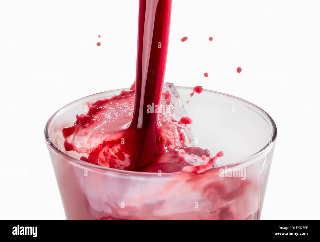 Jus de fruits rouges frais est versé dans le verre Banque D'Images