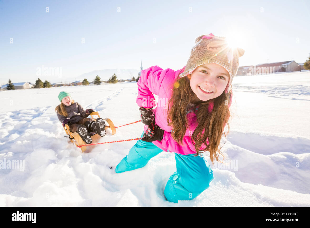 Enfants (8-9, 10-11) jouant avec la neige en traîneau Banque D'Images