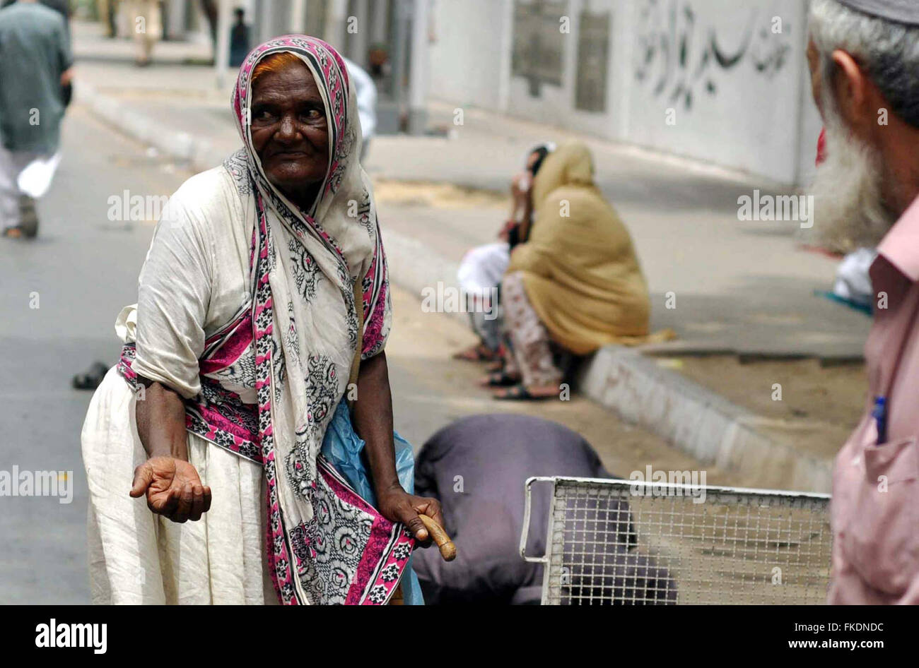 Femme d'âge pauvres mendiant mendie l'aumône à une mosquée près de la route à l'occasion de la Journée internationale des femmes à M.A Jinnah road à Karachi le Mardi, Mars 08, 2016. Banque D'Images