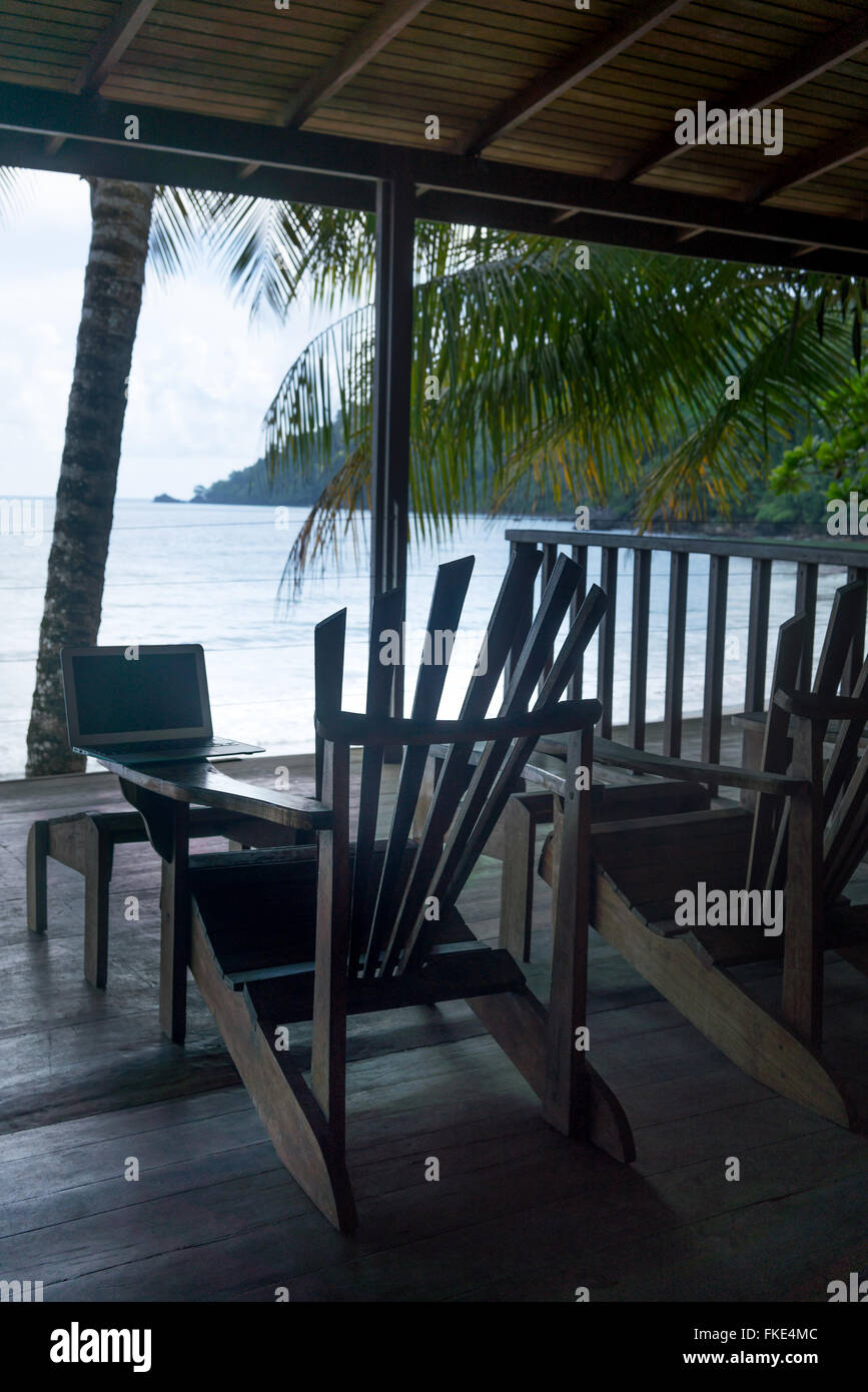 Ordinateur portable sur chaise Adirondack à une station touristique et la mer vue à travers un centre touristique, la Trinité, Trinité-et-Tobago Banque D'Images