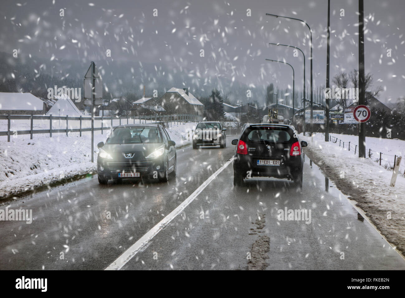 Voitures sur route glissante lors d'une forte averse de neige humide hivernal dangereux causant des conditions de conduite en hiver / printemps Banque D'Images