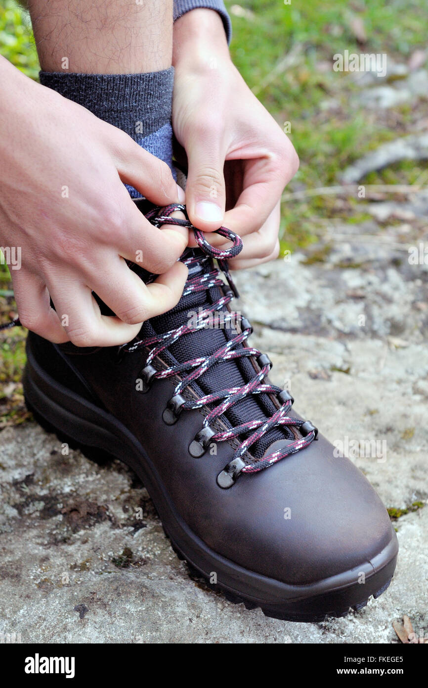Attacher les lacets de chaussures de randonnée devant la montagne à pied  Photo Stock - Alamy