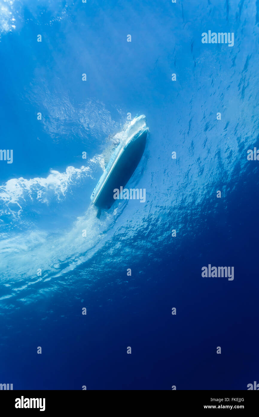 Sous-vue de bas de bateau de plongée de surface sur les eaux bleu avec un motif de vagues et des bulles Banque D'Images