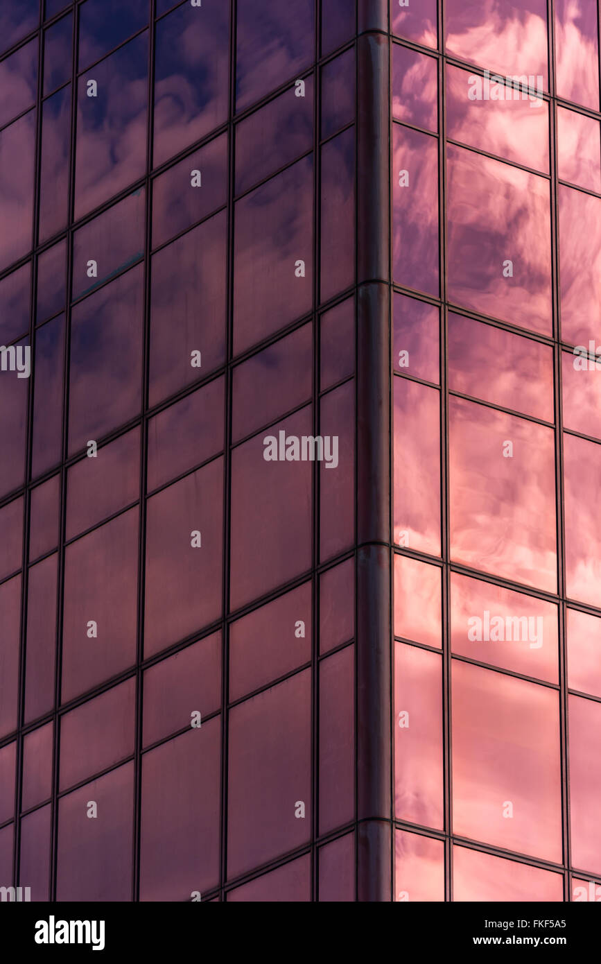 Ciel et nuages reflétée dans windows d'immeuble de bureaux moderne rose Banque D'Images