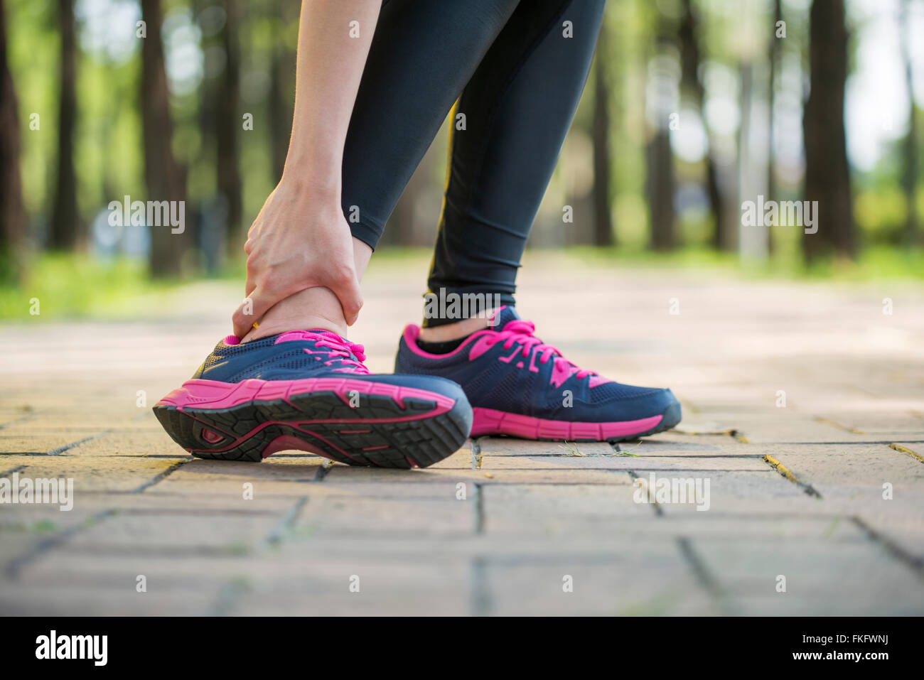 Woman runner tenir la douleur de cheville tordue ,Human Foot crampon Banque D'Images