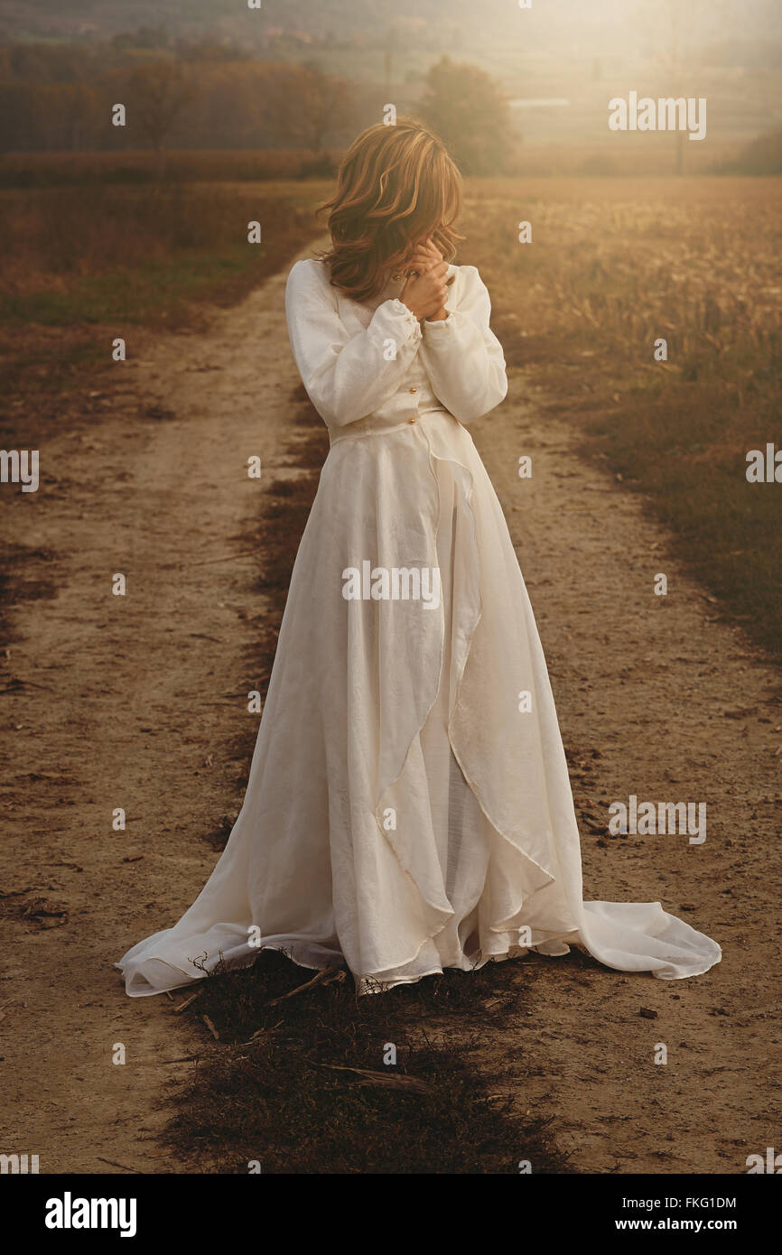 Femme seule avec bride dress vintage dans la campagne . Pureté et d'innocence Banque D'Images