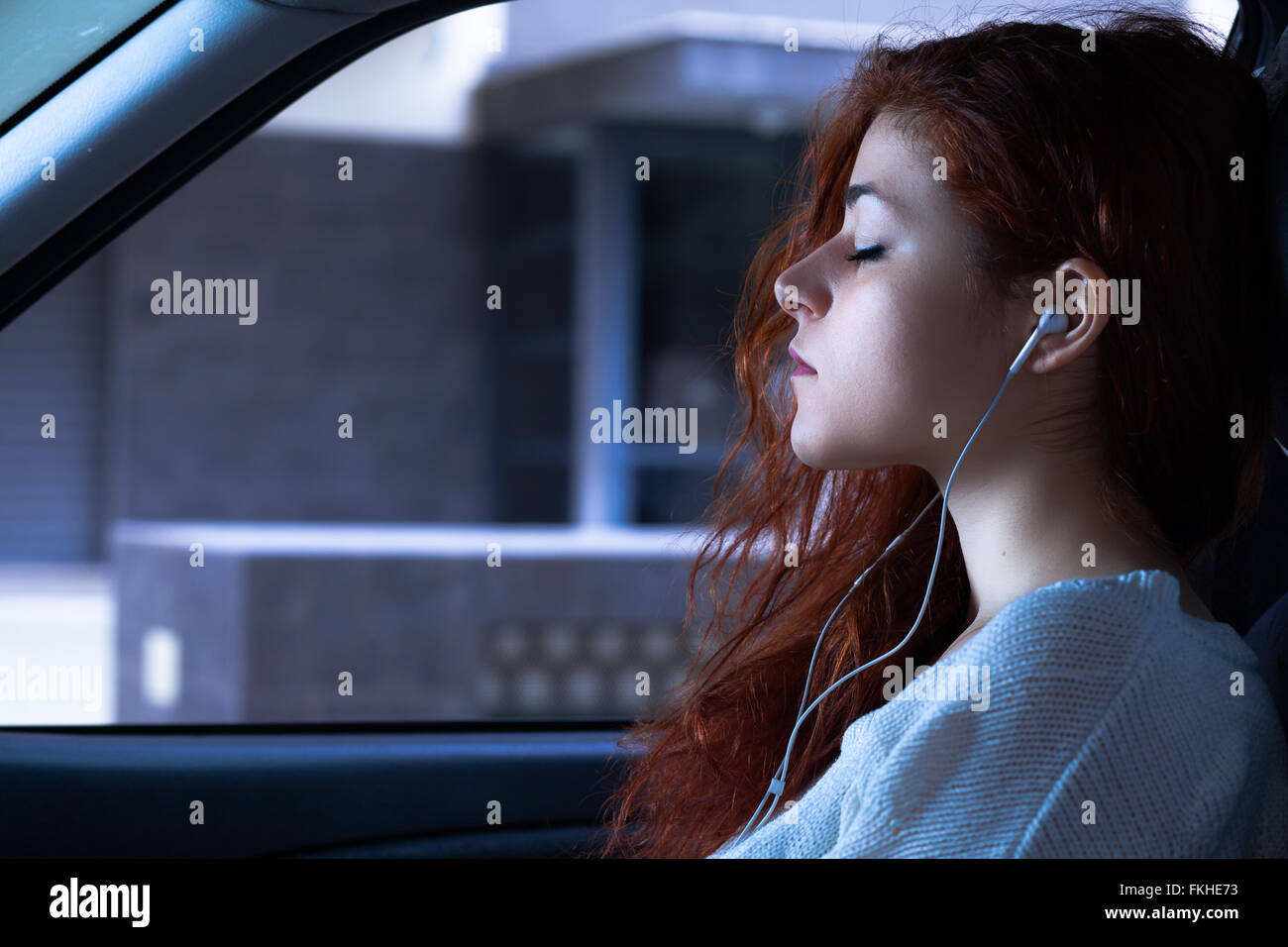 Femme avec des écouteurs à écouter de la musique dans une voiture Banque D'Images