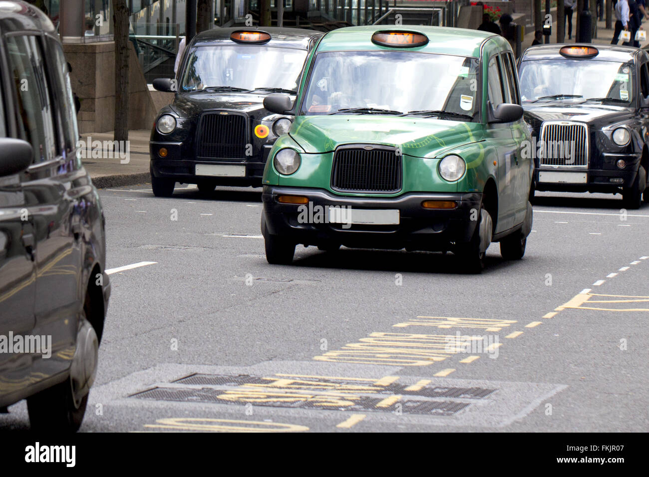 Quatre lieux emblématiques, célèbre London Taxis taxi noir voyager dans Canary Wharf Banque D'Images