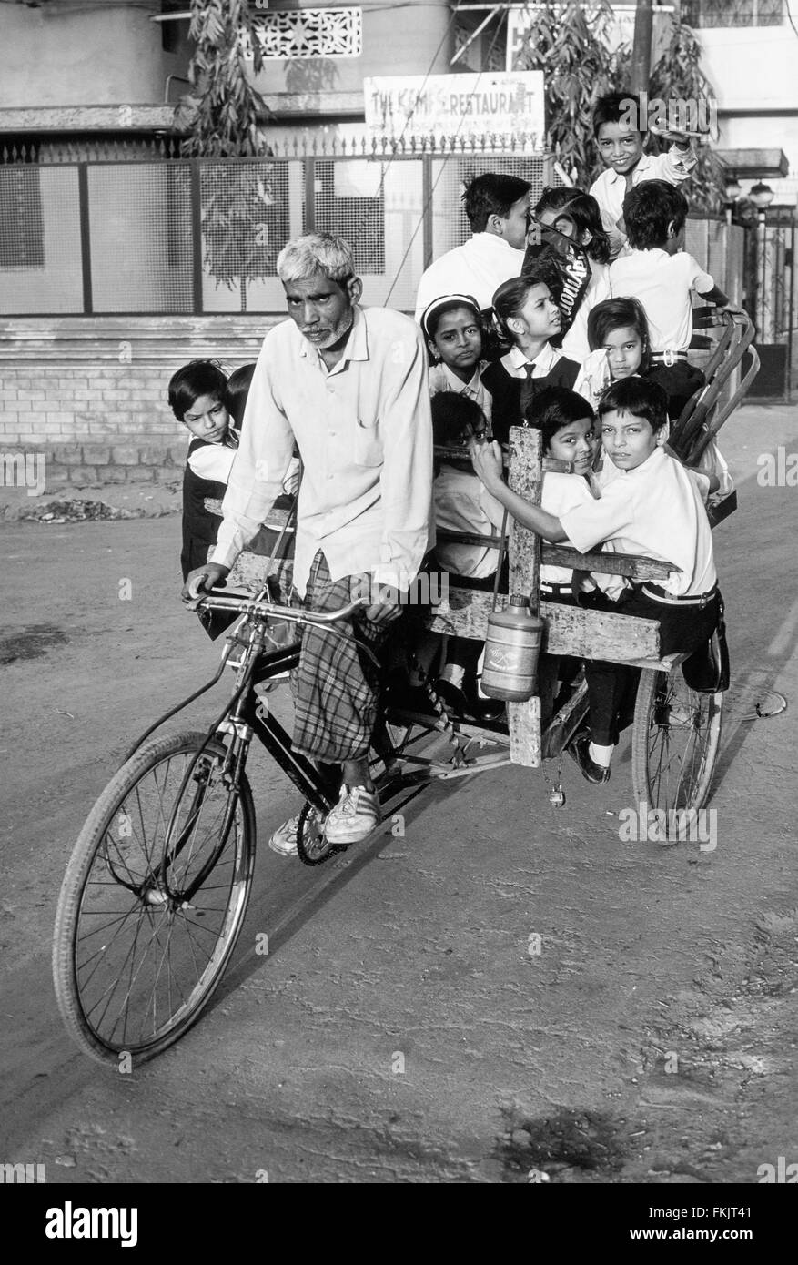 Vélo, pousse-pousse, rider, chauffeur, taxi, avec son tarif matin de grand groupe, de l'école, les enfants, qu'il prend à l'école.Varanasi, Inde Banque D'Images