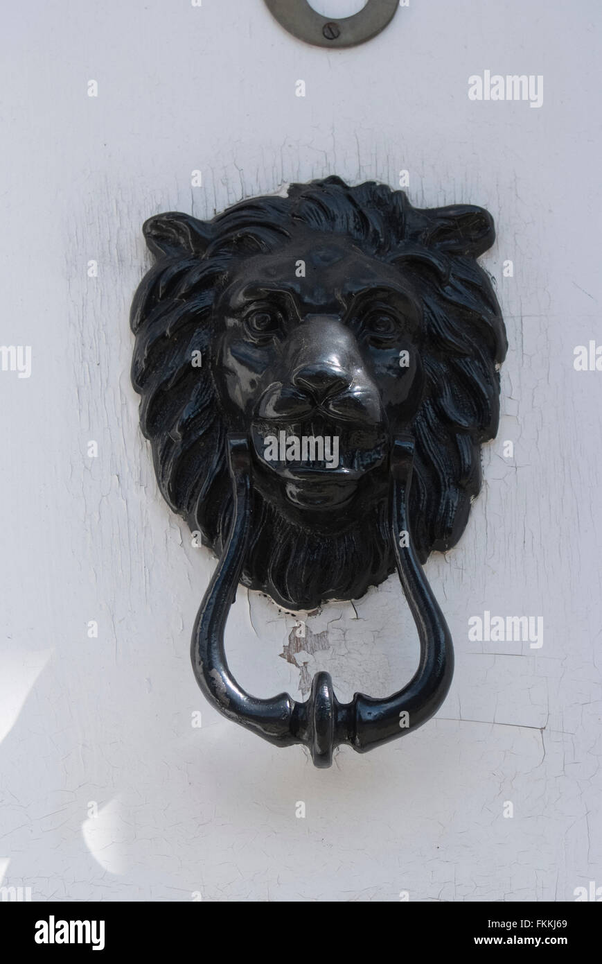 Une tête de lion noir heurtoir sur une porte, d'une maison d'habitation. Banque D'Images