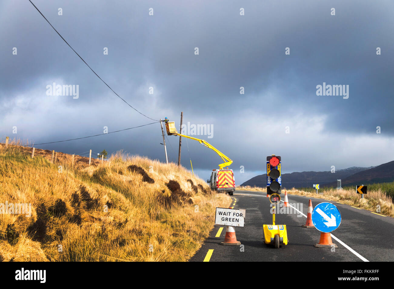 Un homme travaille sur le câble de téléphone dans l'Irlande rurale pôle près de Glenties, comté de Donegal Banque D'Images