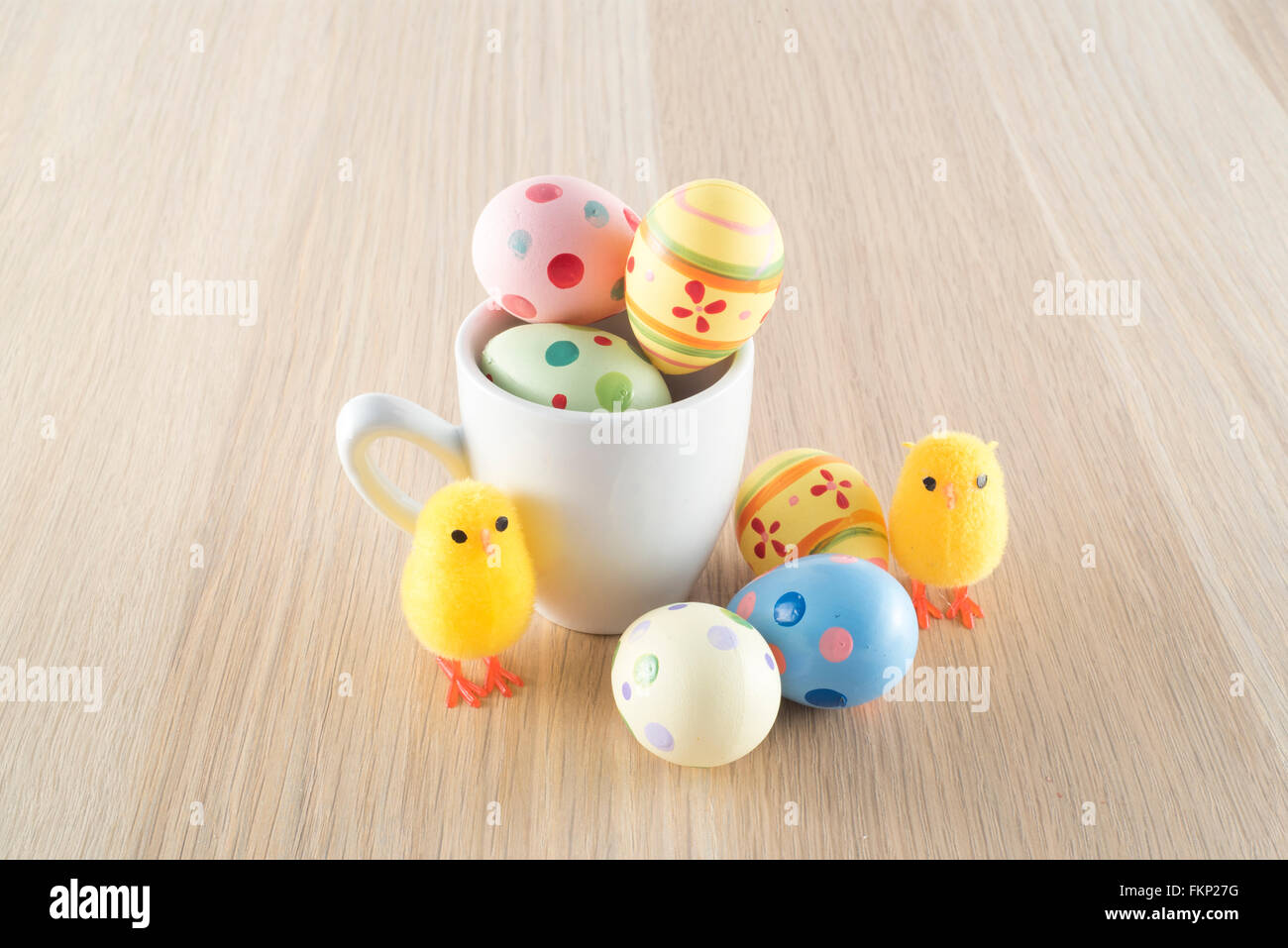 Pâques, petit poussin et les oeufs colorés dans une tasse à café Banque D'Images