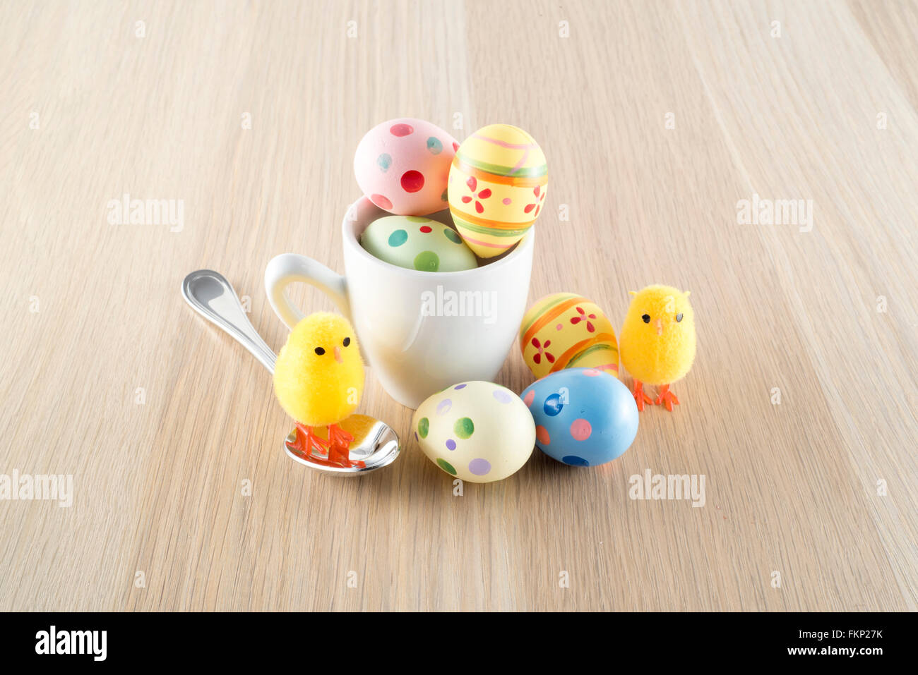Pâques, petit poussin et les oeufs colorés dans une tasse à café Banque D'Images
