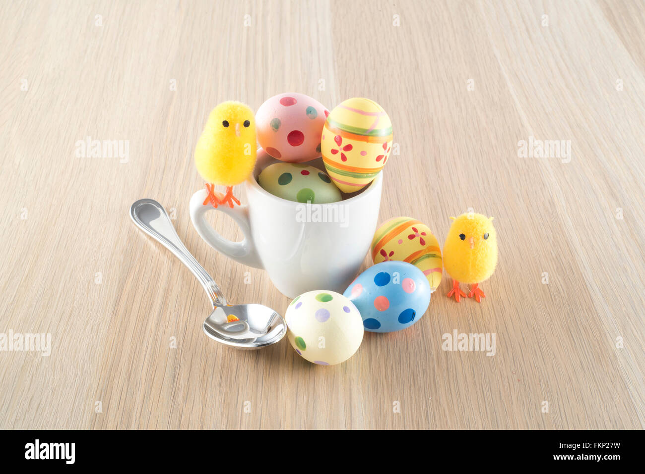 Pâques, petit poussin et les oeufs colorés dans une tasse à café Banque D'Images