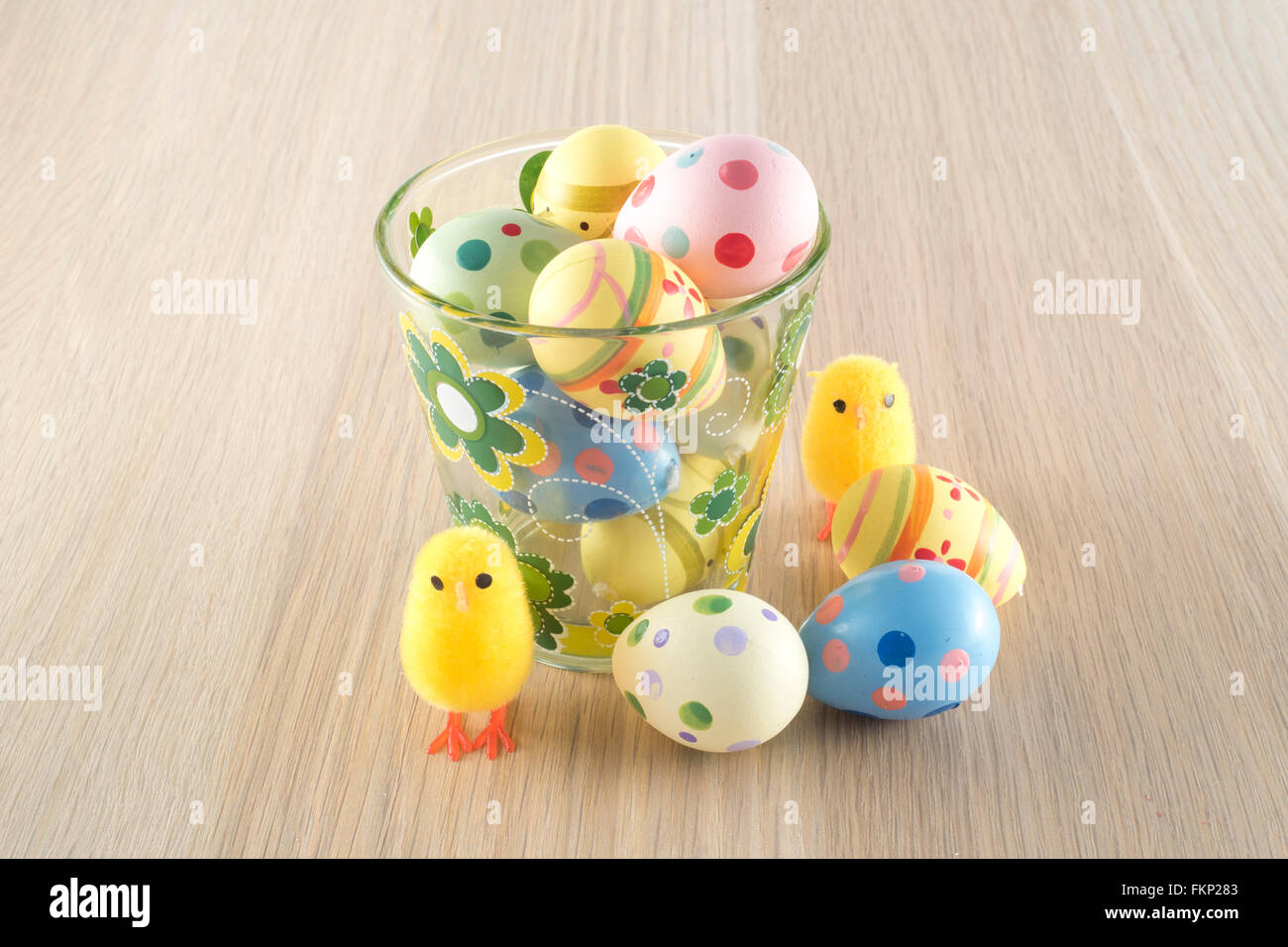 Pâques, petit poussin et les oeufs colorés dans un verre Banque D'Images
