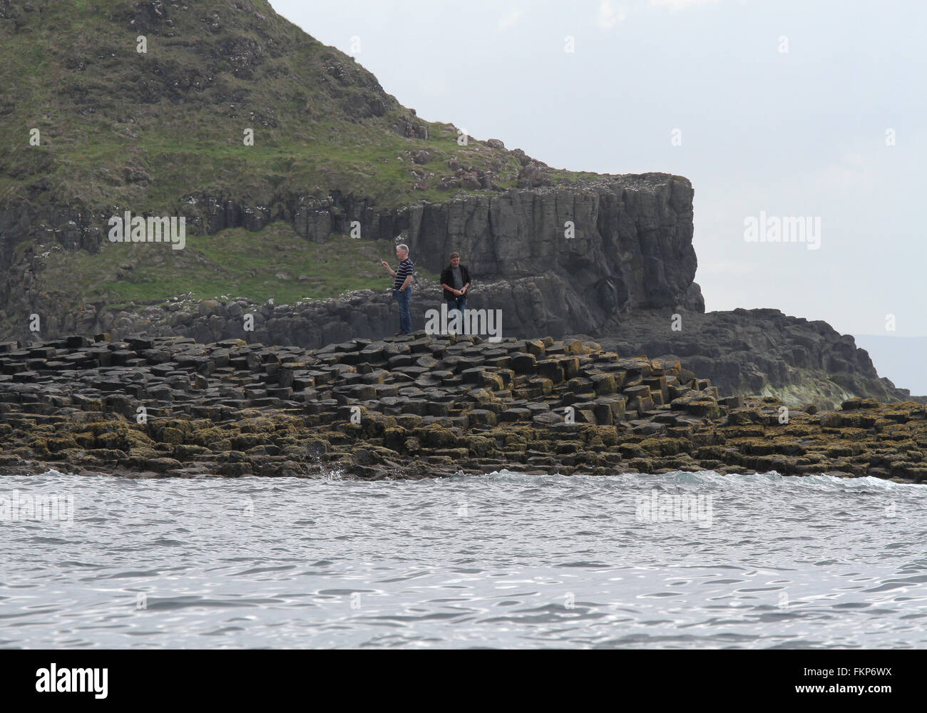 Les touristes la marche sur la Chaussée des Géants , le Comté d'Antrim, en Irlande du Nord. Banque D'Images