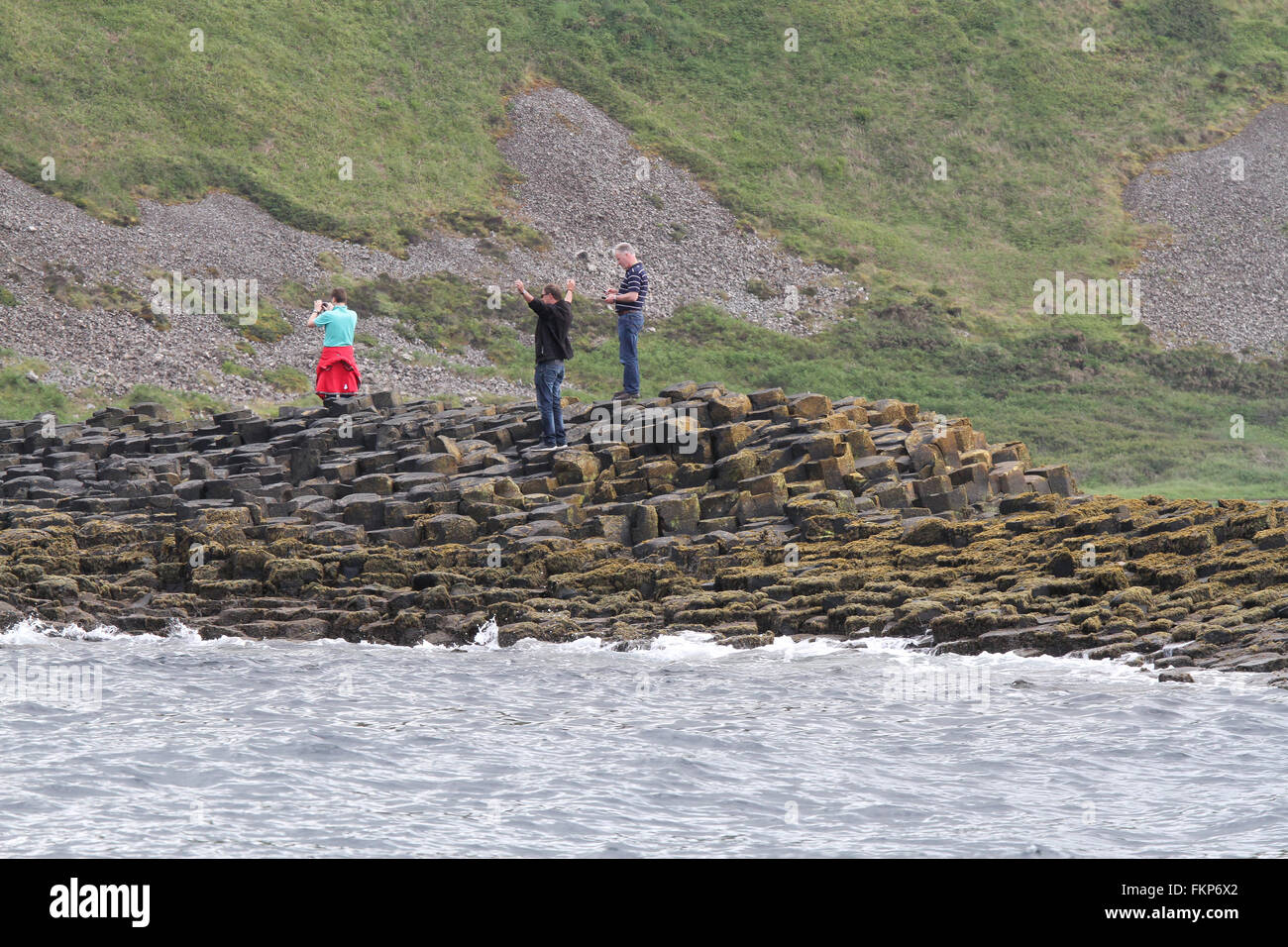 Les touristes la marche sur la Chaussée des Géants , le Comté d'Antrim, en Irlande du Nord. Banque D'Images