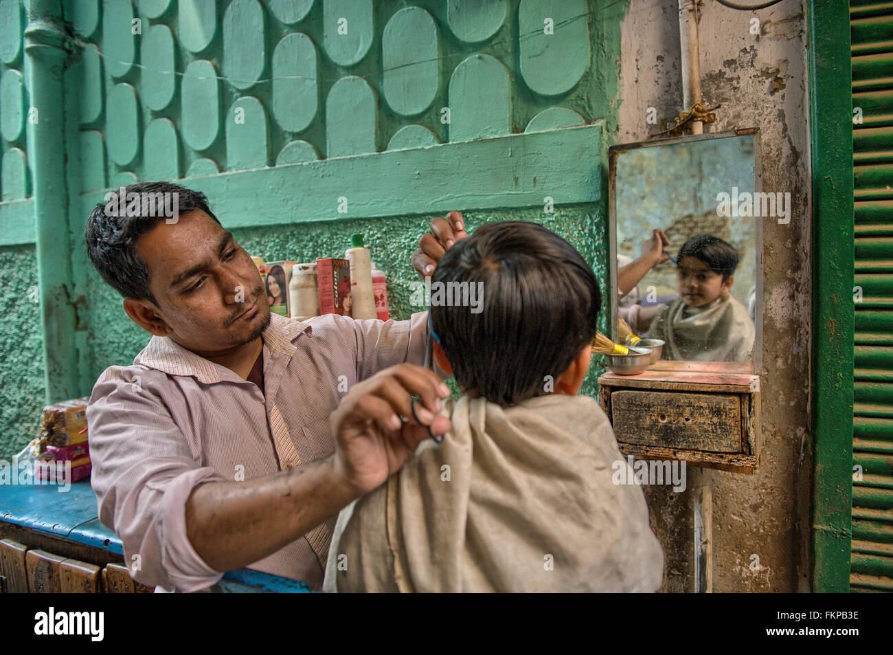 La population locale dans la rue de vieux Delhi. Salon de Coiffure de la rue est un populaire indiens droits fondamenteux. Banque D'Images