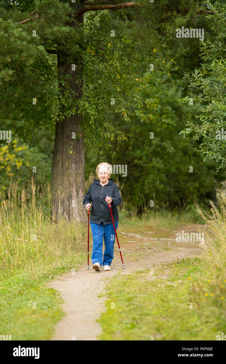 Une femme âgée s'est engagé dans la marche nordique dans la nature. Banque D'Images
