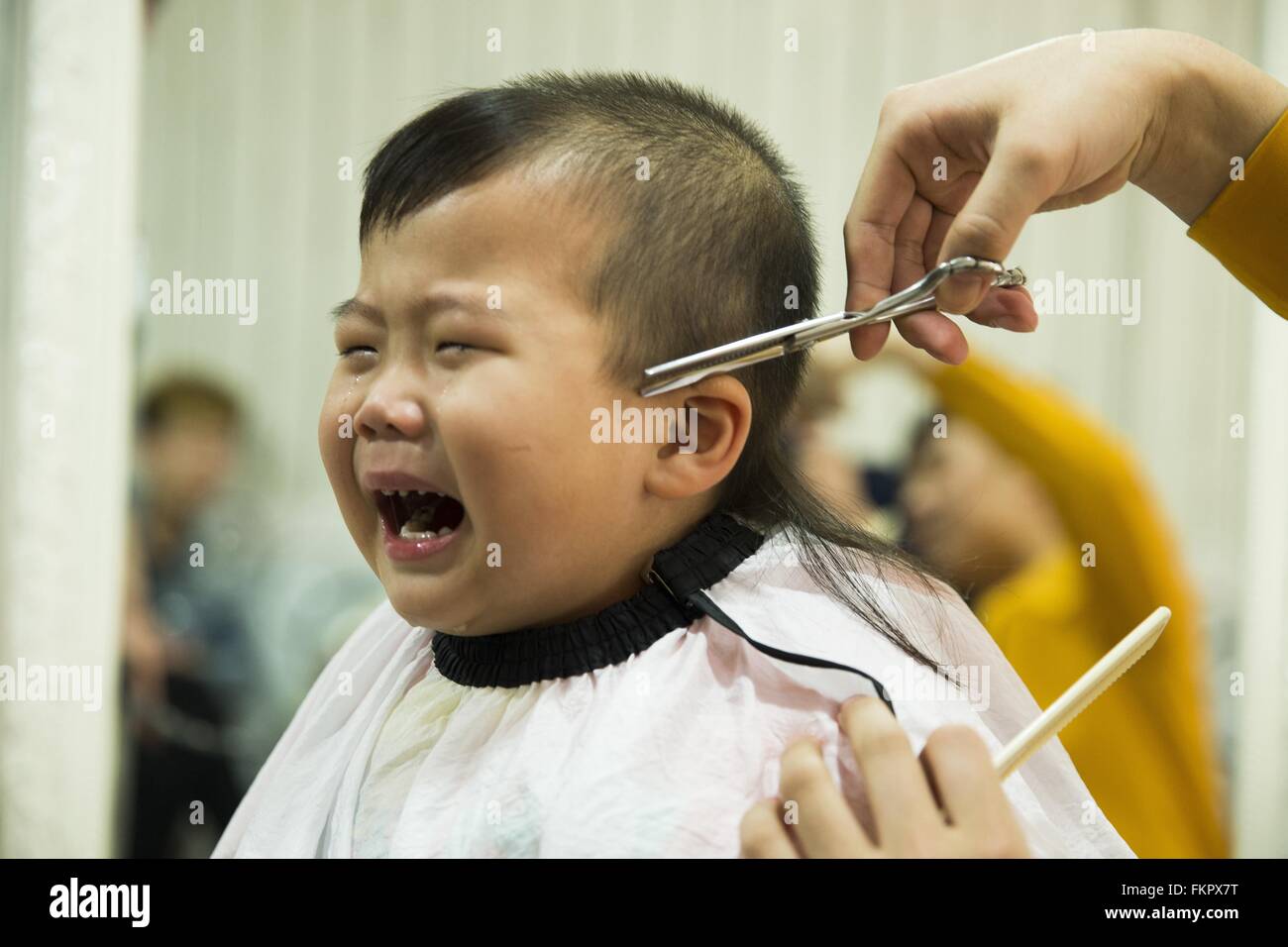 Huludao, province de Liaoning en Chine. 10 Mar, 2016. Un enfant pleure comme une coiffure lui donne une coupe de cheveux à un coiffeur à l'Longtaitou Festival à Huludao, nord-est de la Chine, la province de Liaoning, 10 mars 2016. Le Longtaitou Eryueer ou Festival, Festival, ce qui signifie 'dragon soulève tête" en chinois, est un festival traditionnel chinois tenue le deuxième jour du deuxième mois dans le calendrier lunaire chinois. Les Chinois détiennent la conviction que le fait d'obtenir une coupe quand le 'dragon soulève sa tête' signifie qu'ils auront un départ énergique à la nouvelle année. © Tian Jia/Xinhua/Alamy Live News Banque D'Images
