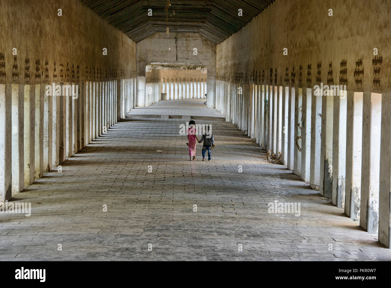 Frère et sœur marcher dans le corridor pour Shwezagon Pagode, à Bagan, Myanmar Banque D'Images