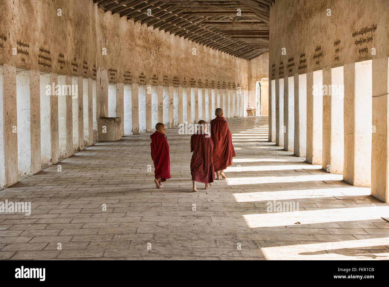 La marche des moines dans le couloir d'entrée de Shwezigon Paya, Bagan, Myanmar Banque D'Images