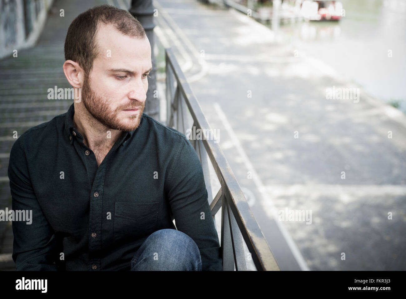 Caucasian man sitting on escalier extérieur Banque D'Images