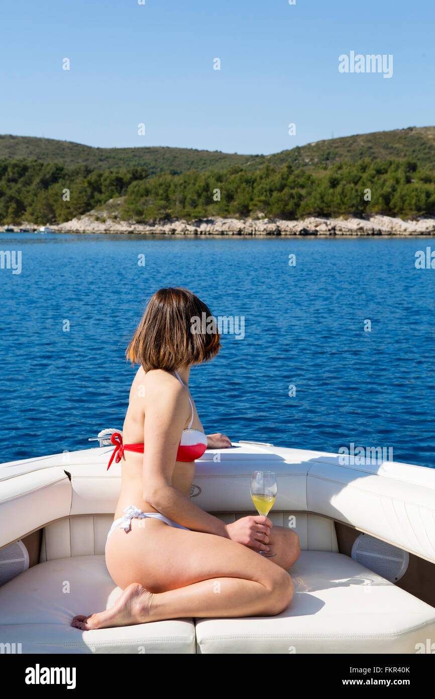 Woman drinking cocktail on boat in ocean Banque D'Images