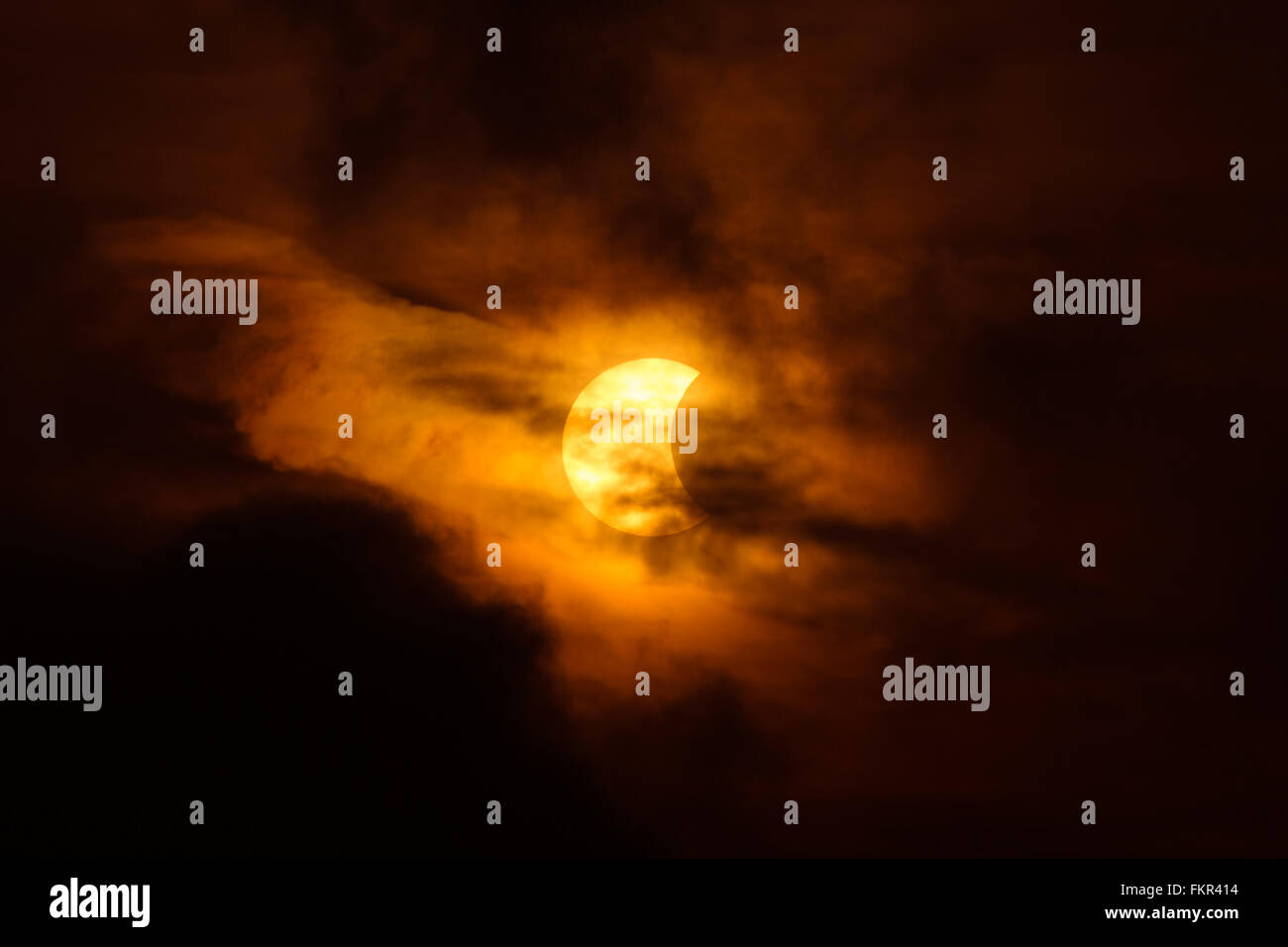 Éclipse solaire partielle (environ 41  %) derrière le nuage sombre à Bangkok, Thaïlande, le 9 mars 2016. Banque D'Images