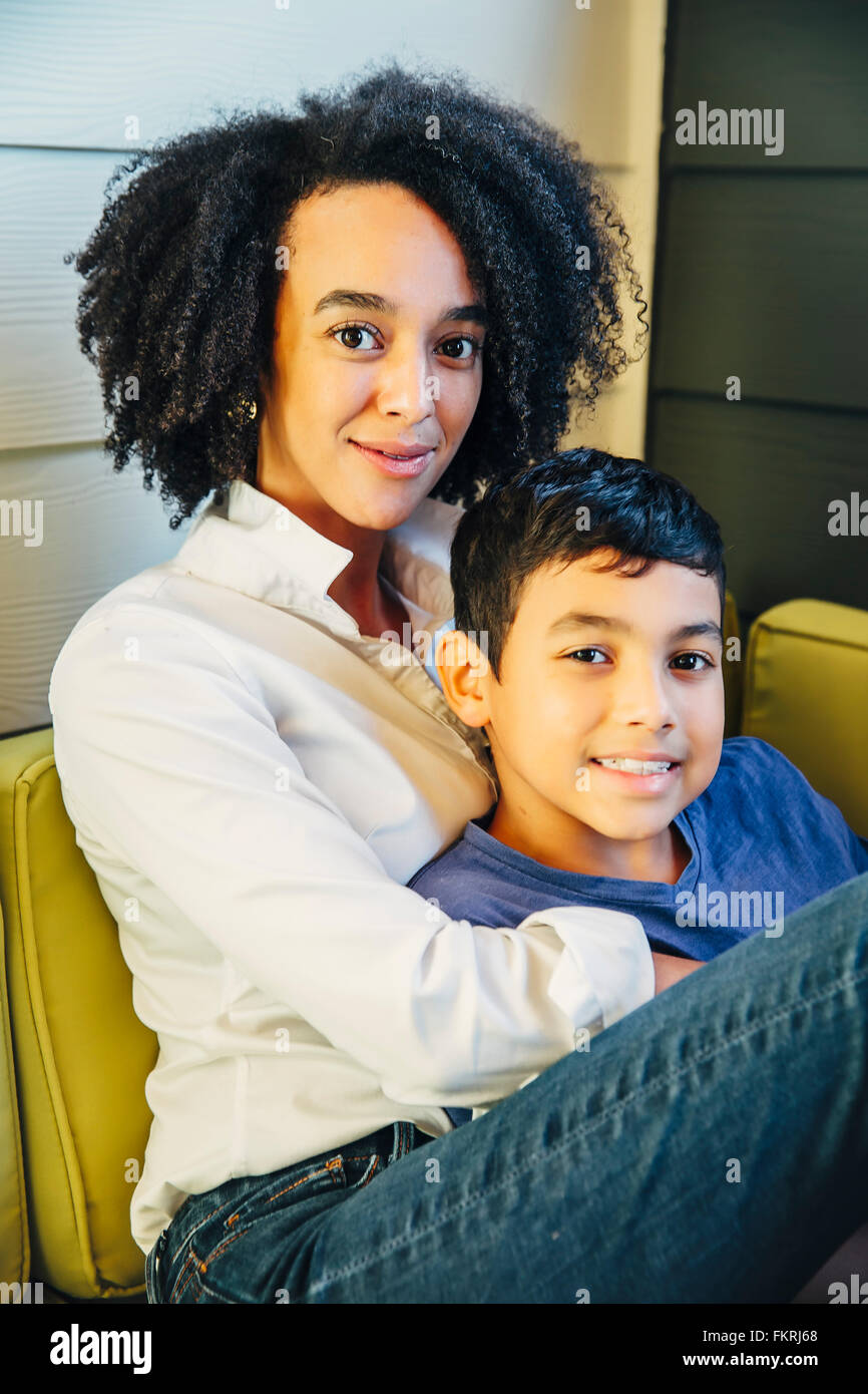 Mother hugging son on sofa Banque D'Images