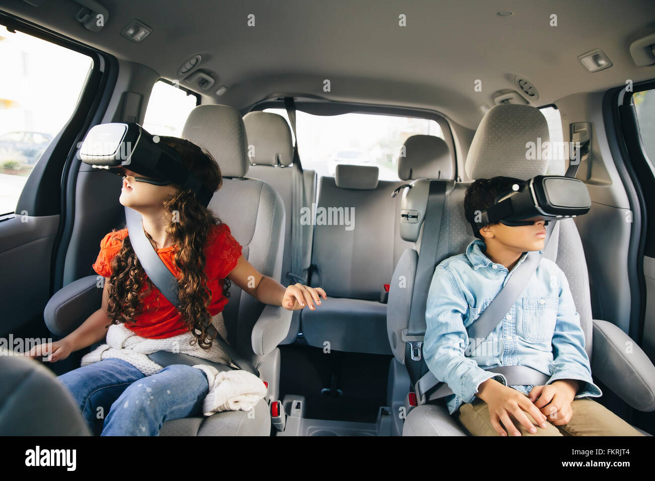 Mixed Race enfants utilisant des lunettes de réalité virtuelle dans... Banque D'Images