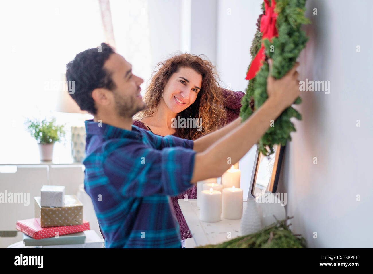 Couple hanging Christmas wreath Banque D'Images