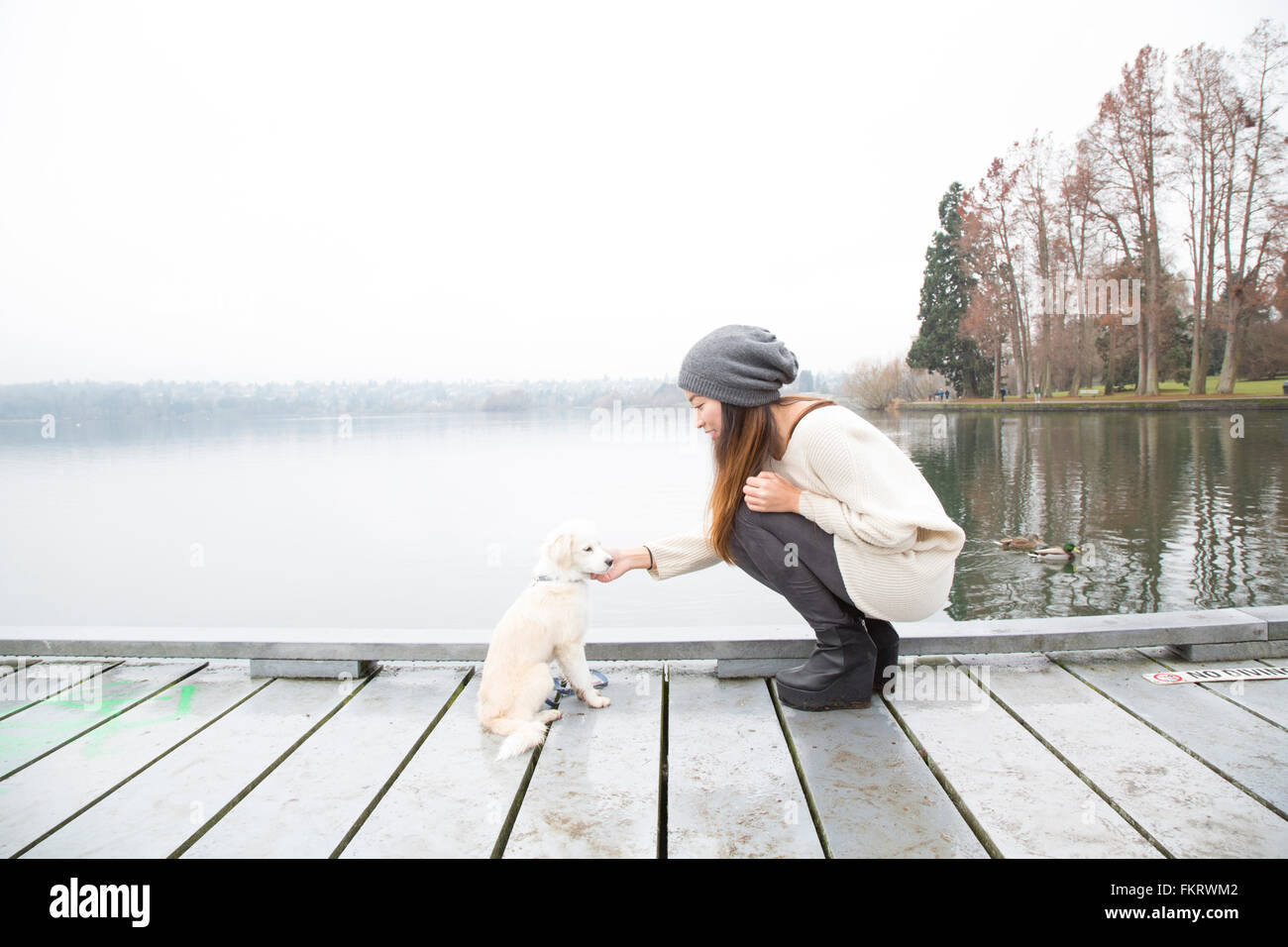 Japanese woman petting dog près du lac Banque D'Images