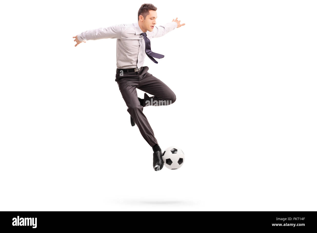 Studio shot of young woman playing football tourné en l'air isolé sur fond blanc Banque D'Images