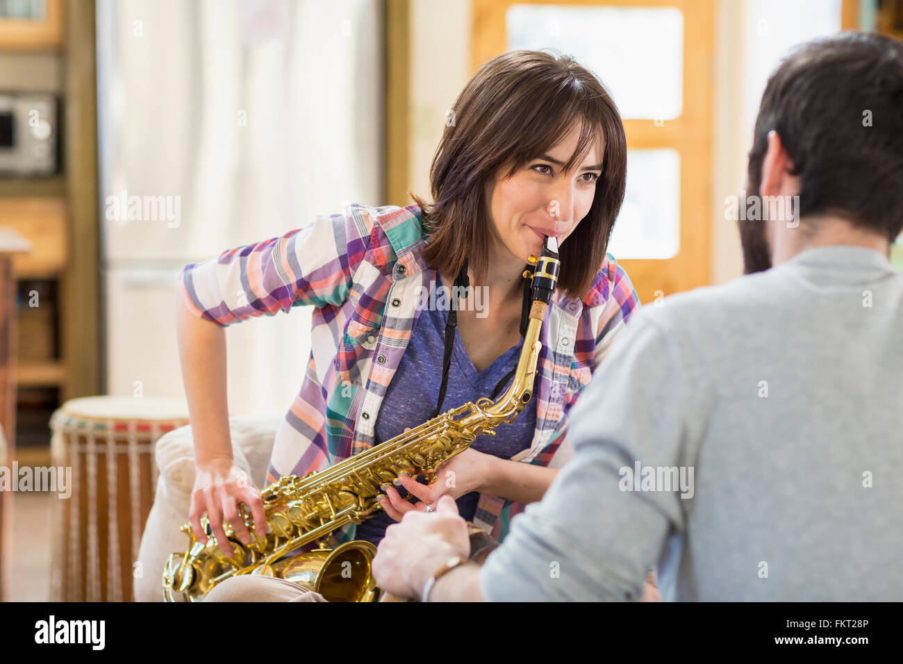 Man Watching copine à jouer du saxophone Banque D'Images