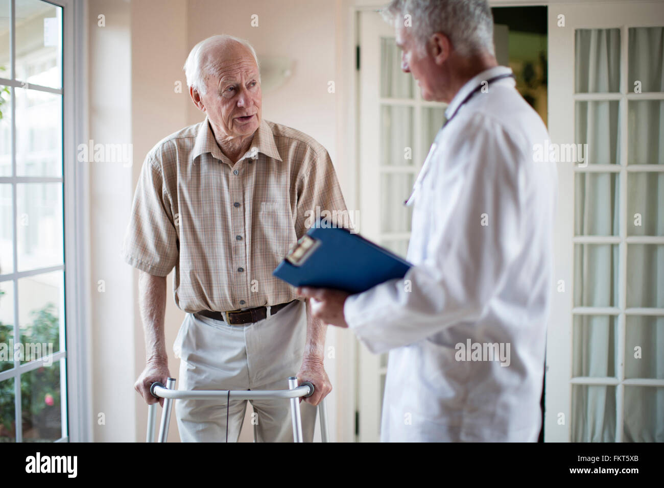 Doctor talking to patient à l'aide de Walker Banque D'Images