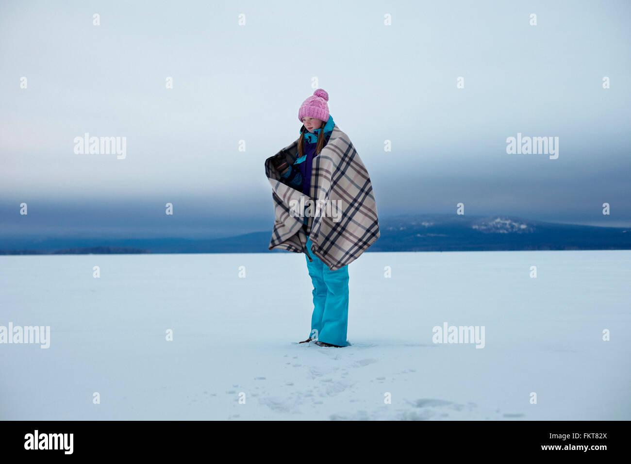 Portrait of teenage girl wrapped in blanket in snow Banque D'Images