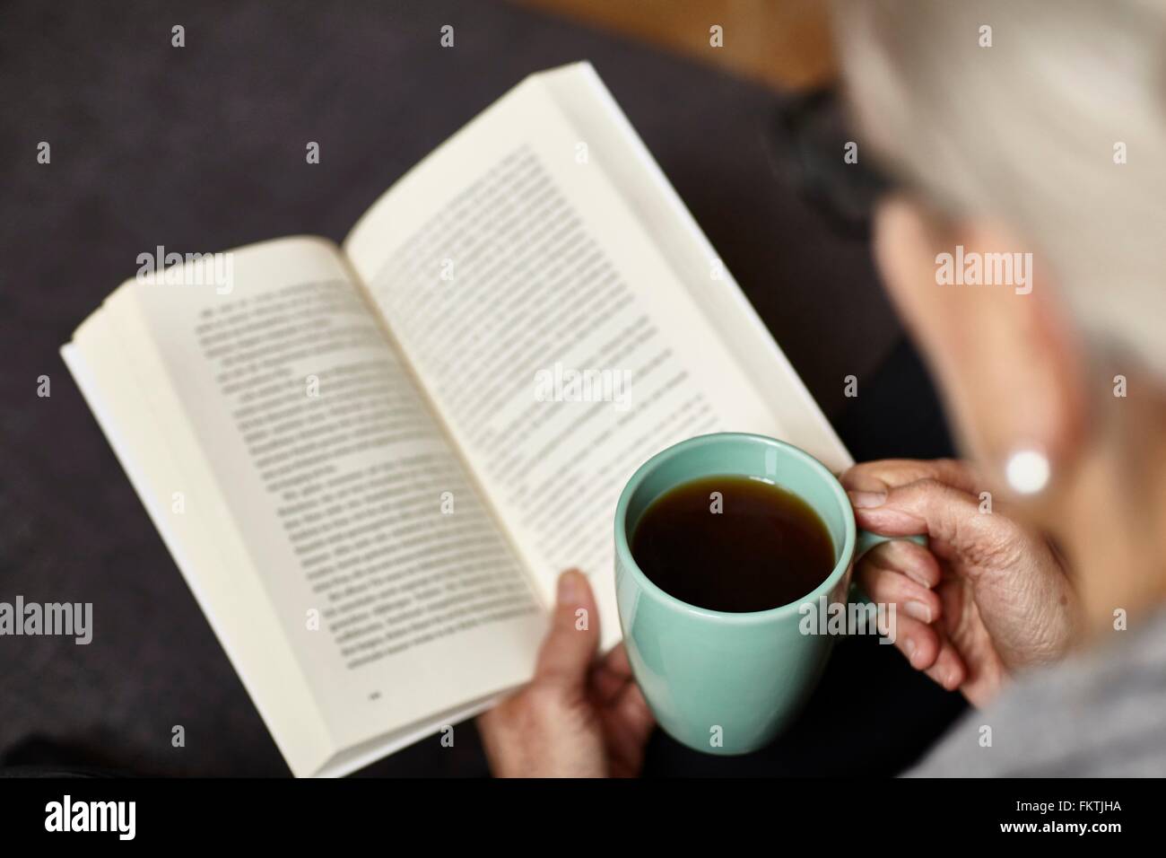 Woman having coffee et la lecture Banque D'Images