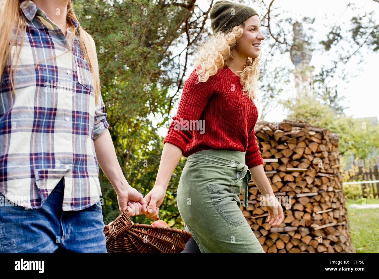 Deux femmes portant des pommes dans le panier de jardin Banque D'Images