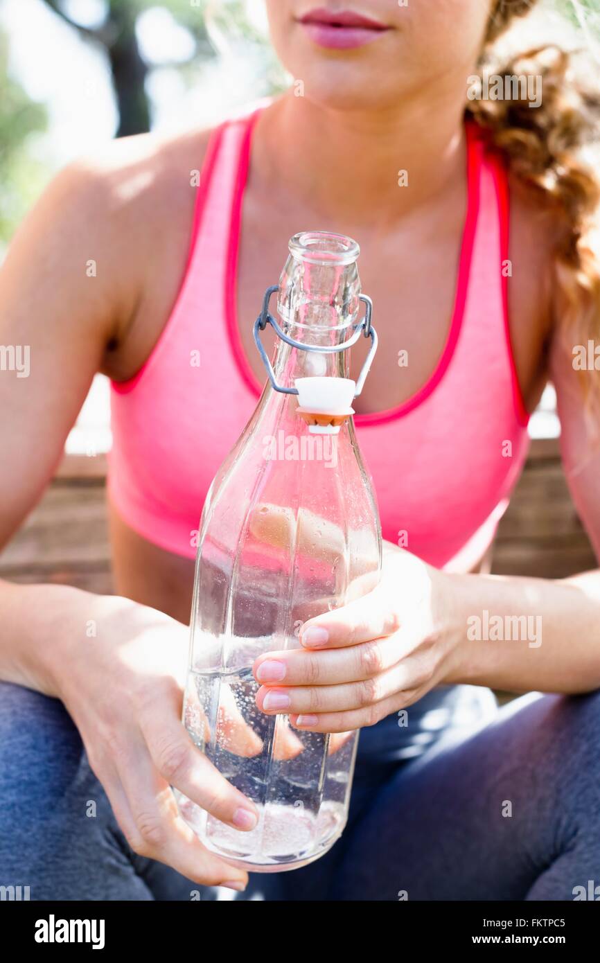 Femme tenant le flacon en verre avec de l'eau minérale Banque D'Images