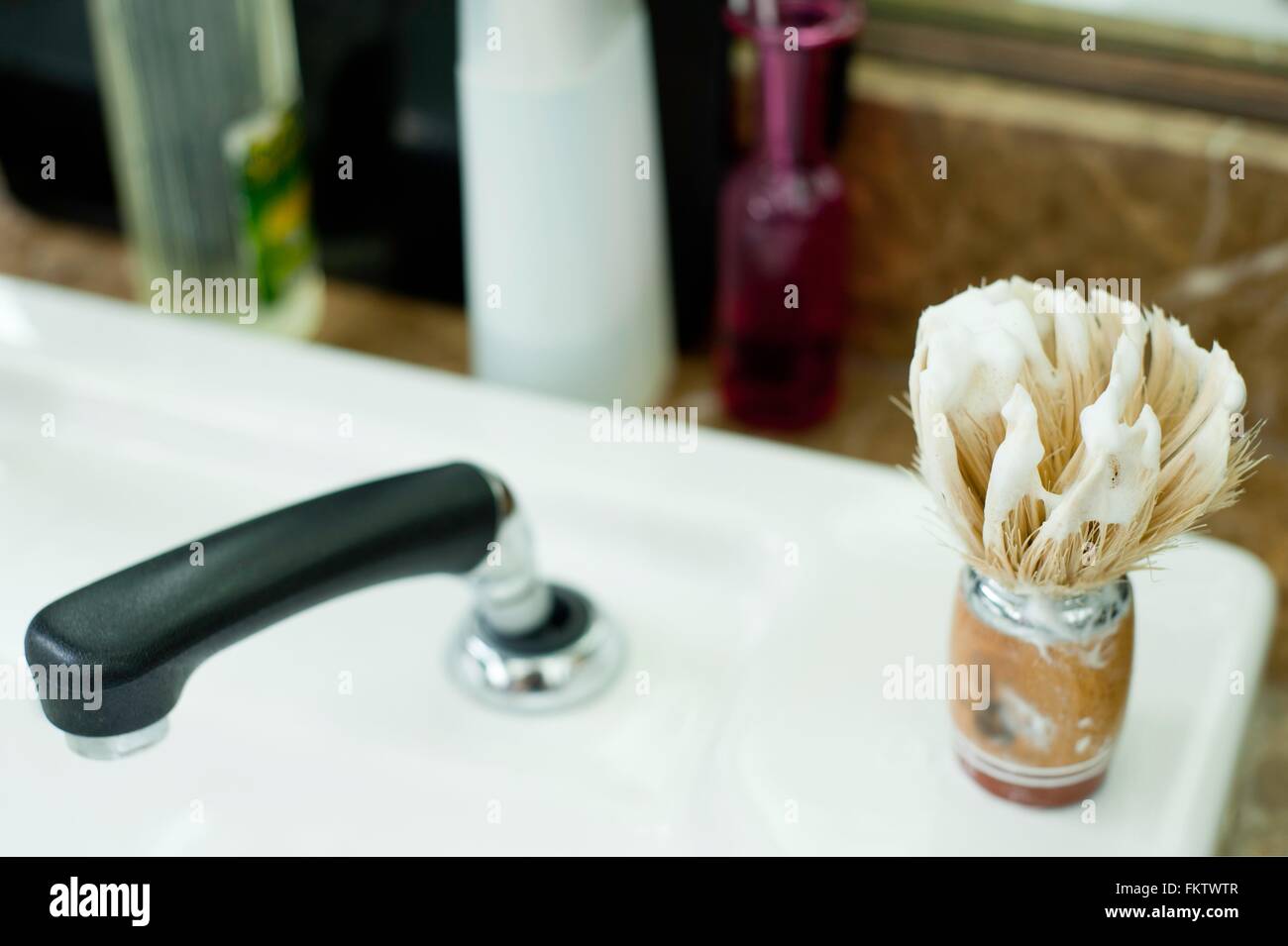 Crème de Rasage blaireau couverts sur lavabo dans barbershop Banque D'Images