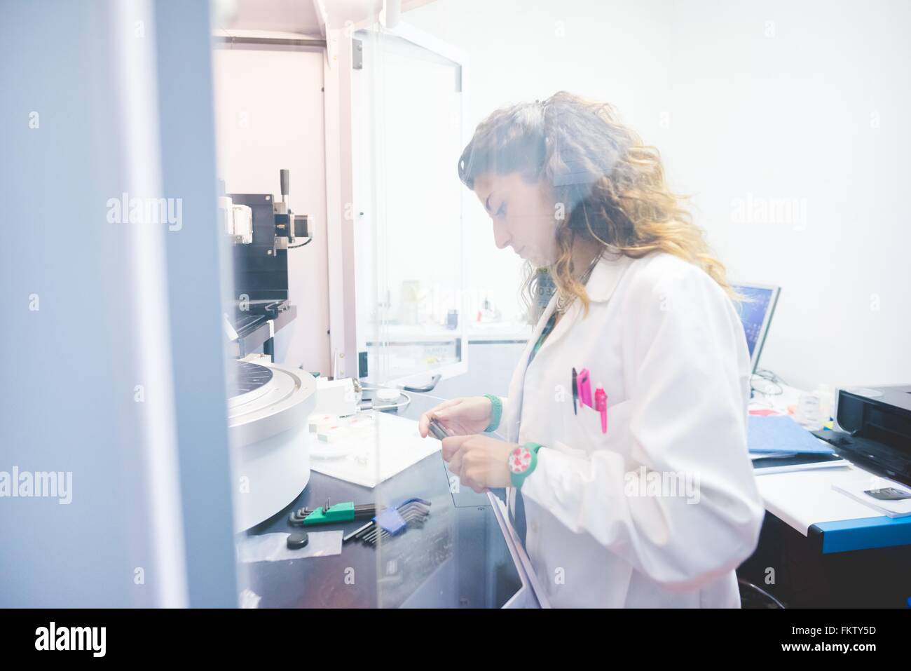 Female scientist la préparation de l'échantillon à film mince à la mesure à l'aide d'un diffractomètre de rayons x Banque D'Images
