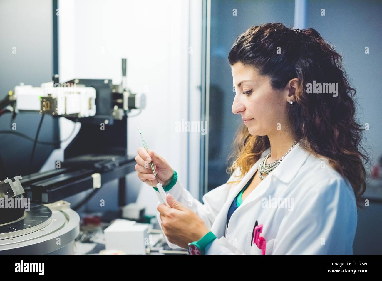 Female scientist la préparation de l'échantillon à film mince à la mesure à l'aide d'un diffractomètre de rayons x Banque D'Images