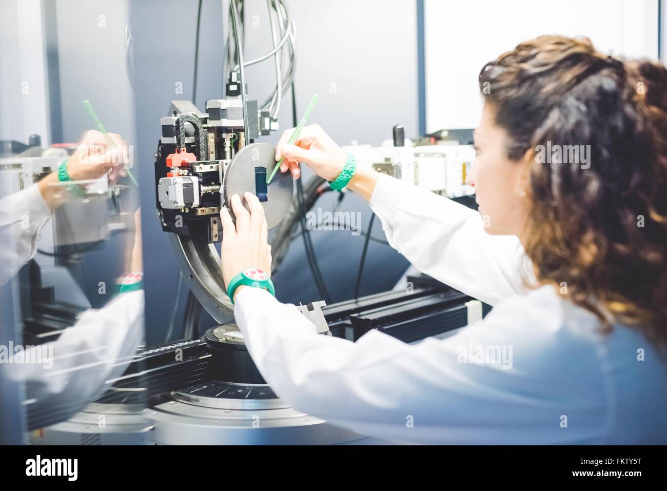 Positionnement scientifique féminin mince film d'essai sur le porte-échantillon sur x-ray diffraction Banque D'Images