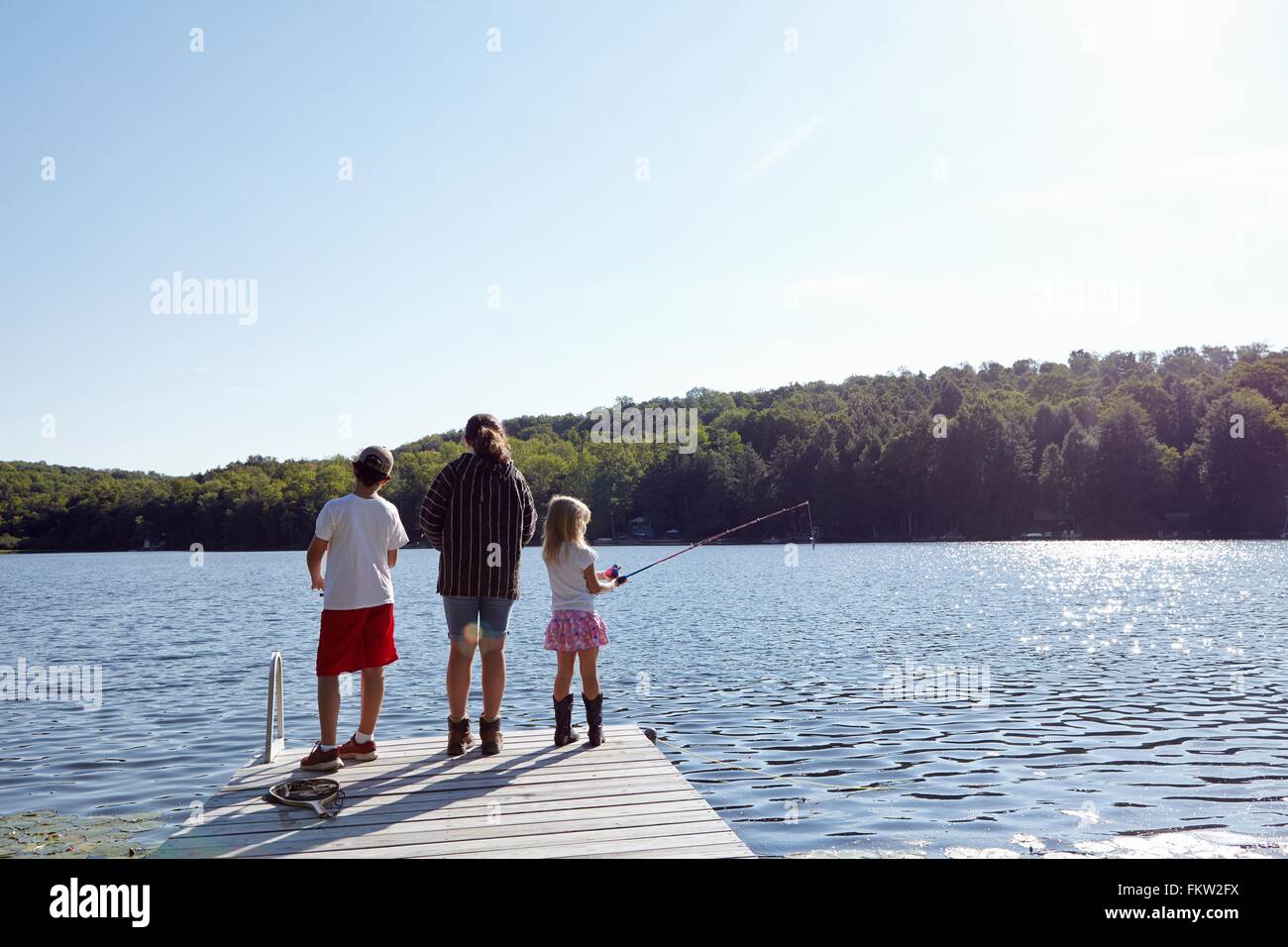 Les enfants de la pêche sur le lac par pier, New Milford, New Jersey, États-Unis Banque D'Images