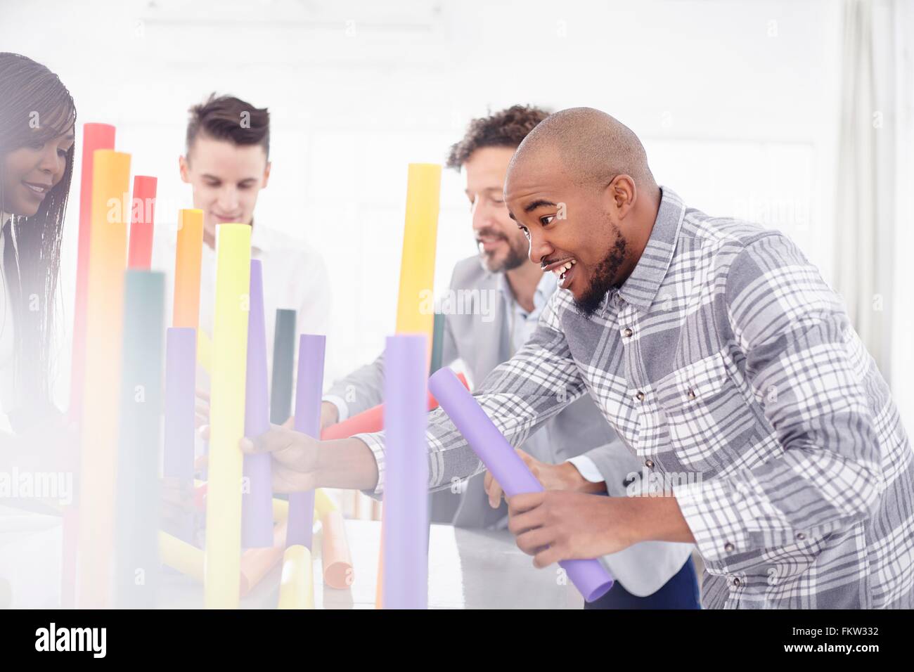 Collègues de l'équipe d'équilibrage des tâches de tubes colorés smiling Banque D'Images